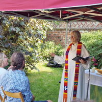 Pastorin Anja Kleinschmidt spricht mit einem Paar im Garten während einer Hochzeitszeremonie in Lüneburg.