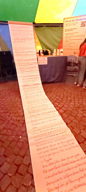 Ein langer Papierstreifen mit handgeschriebenen Notizen steht am Stand des Hauses der Diakonie beim FamTag. | © Name