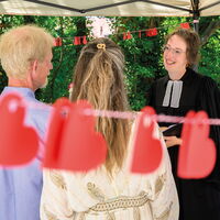 Pastorin Henrike Koch segnet ein Paar auf der Museumsterrasse, umgeben von roten Herzen. | © Jens Möller