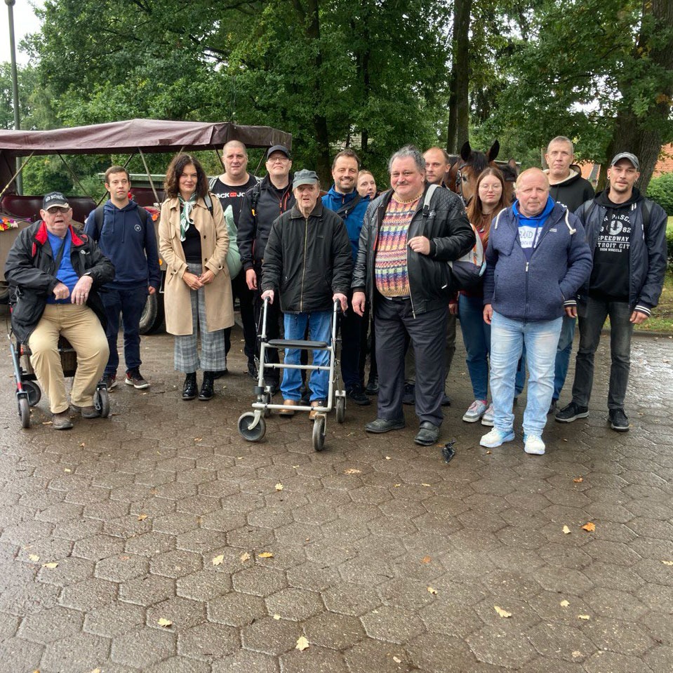 Eine Gruppe von Menschen posiert in der Lüneburger Heide mit einem Pferd für ein gemeinsames Foto.