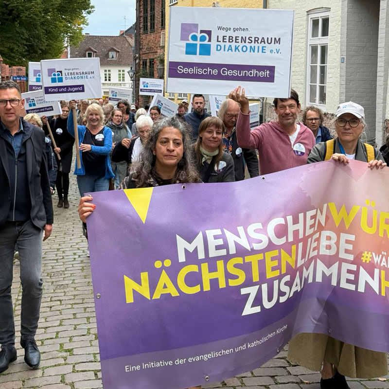 Menschen marschieren für seelische Gesundheit und Nächstenliebe, halten Transparente und Banner hoch.