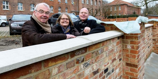 Gruppenbild an neuem Mauerwerk der HerbergePlus.