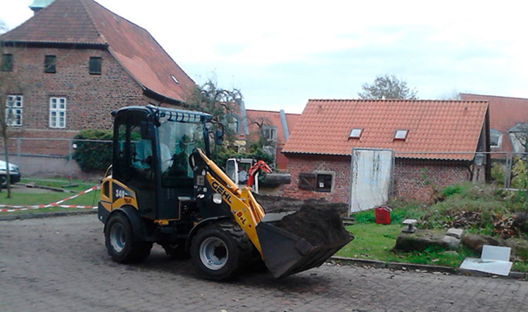 Bagger bei Bauarbeiten am Mauerwerk der HerbergePlus.