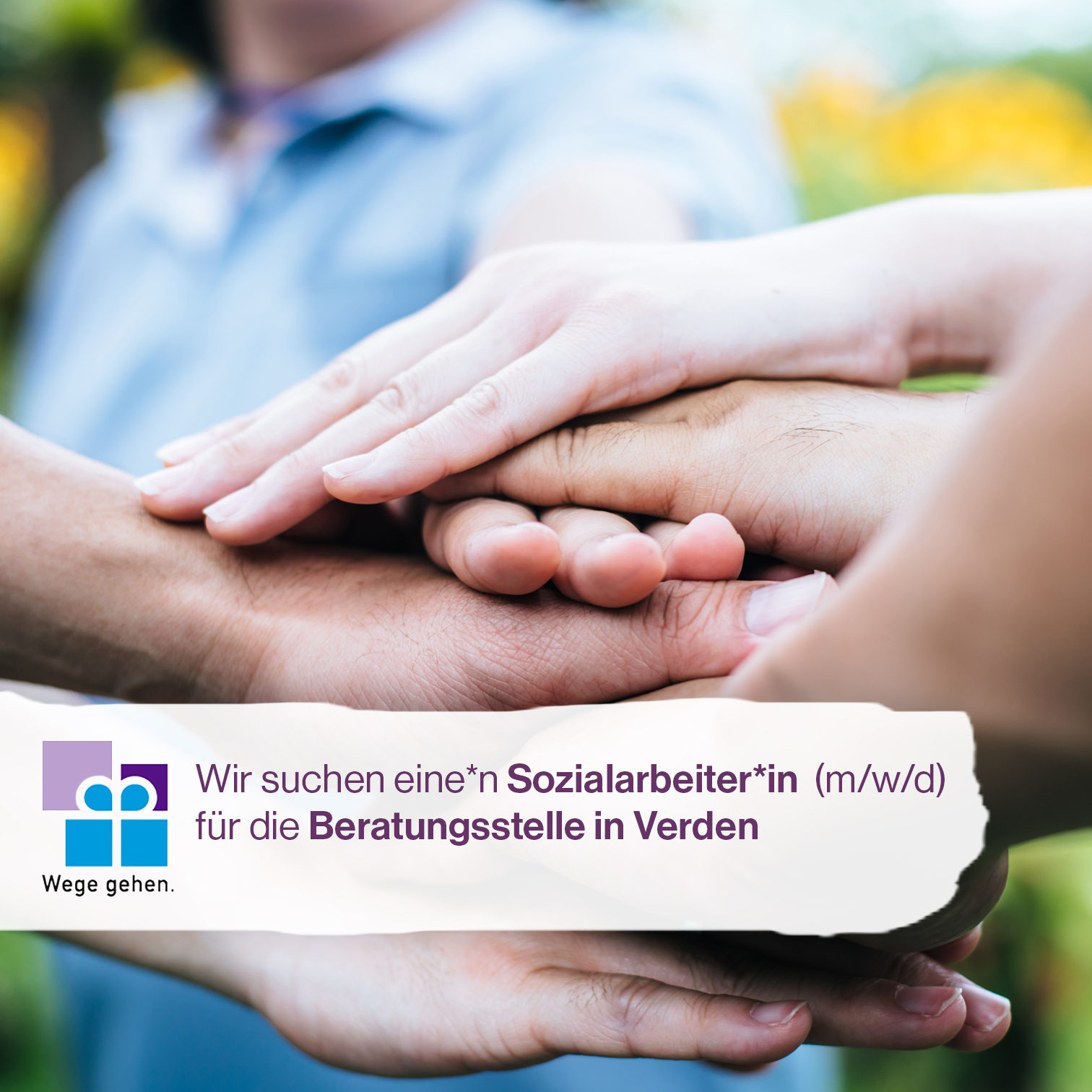 Hände zum Zeichen des Zusammenhalts übereinander gestapelt, im Vordergrund Werbung für Stellenanzeige