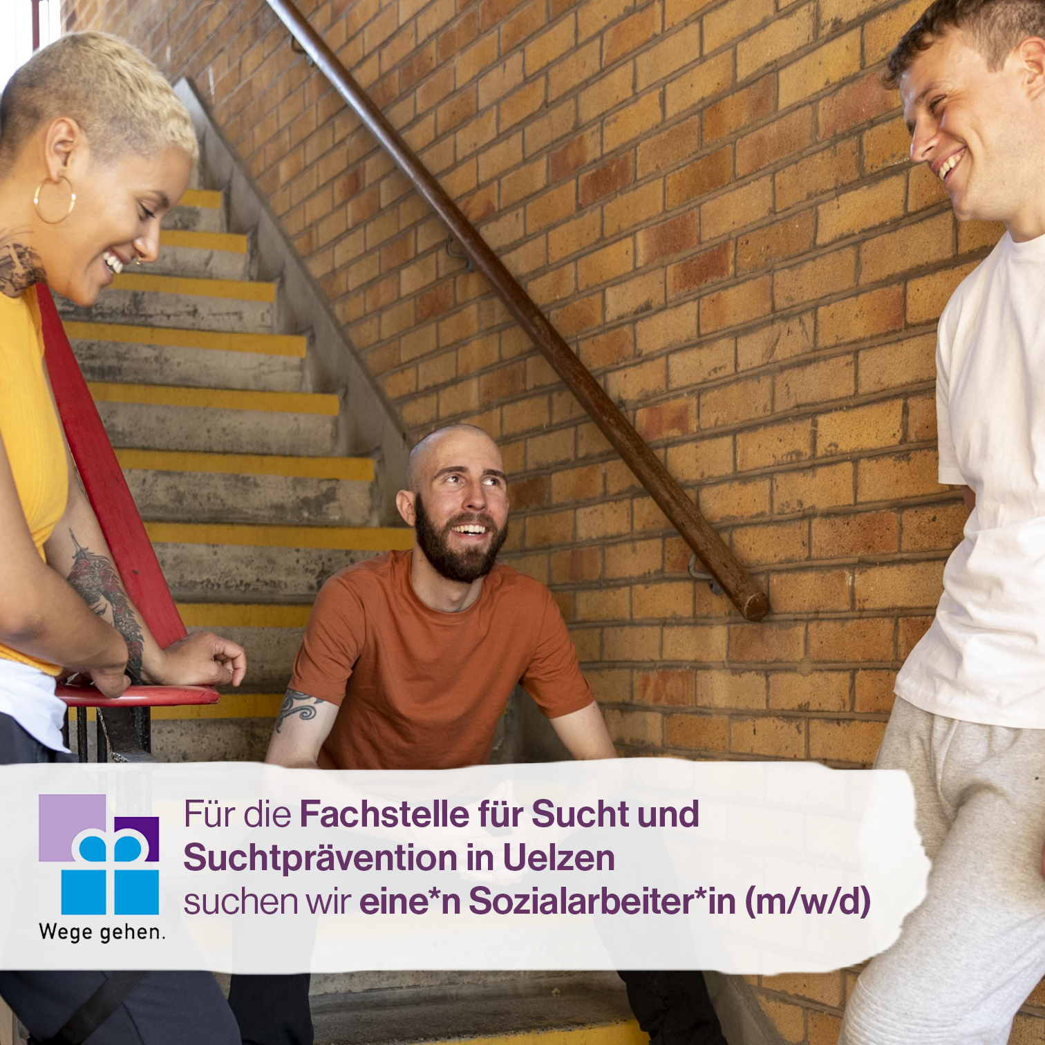 Drei Personen sitzen locker im Treppenhaus und unterhalten sich