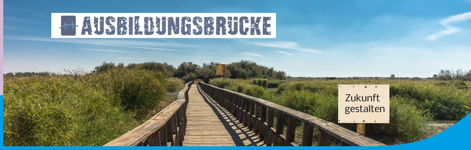 Bild einer langen Holzbrücke in der grünen Natur mit einem Schild mit der Aufschrift "Zukunft gestalten" und dem Logo der Ausbildungsbrücke über das Bild gelegt.